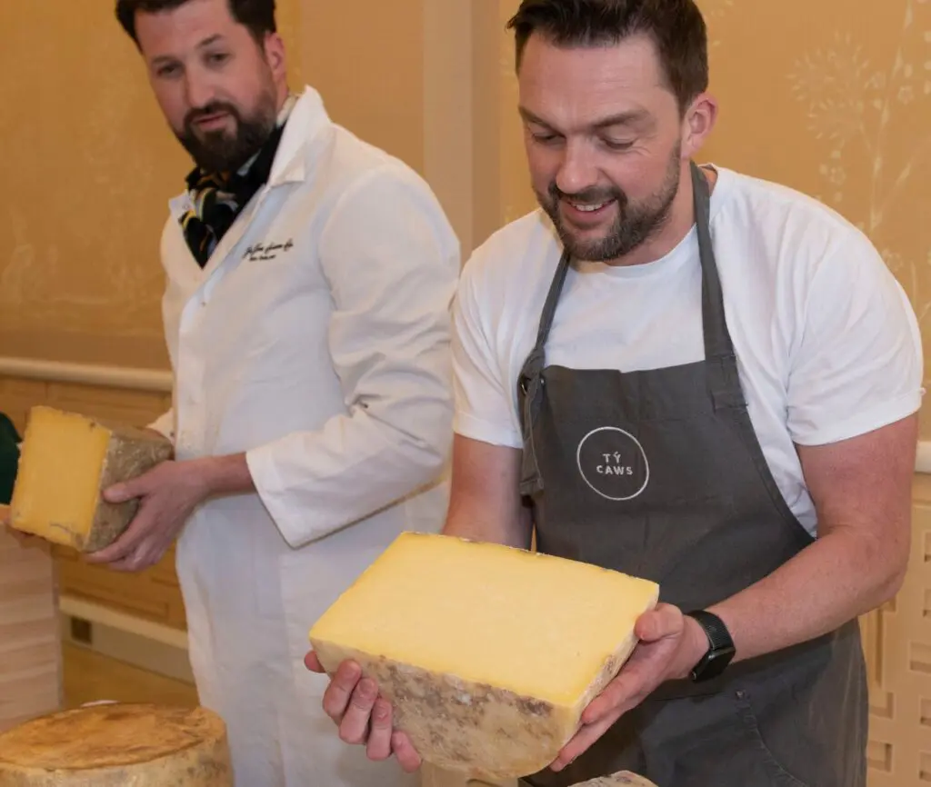 Owen Davies of Ty Caws opening his winning cheddar at Affineur of the Year with Nick Bayne from The Fine Cheese Co. looking on.