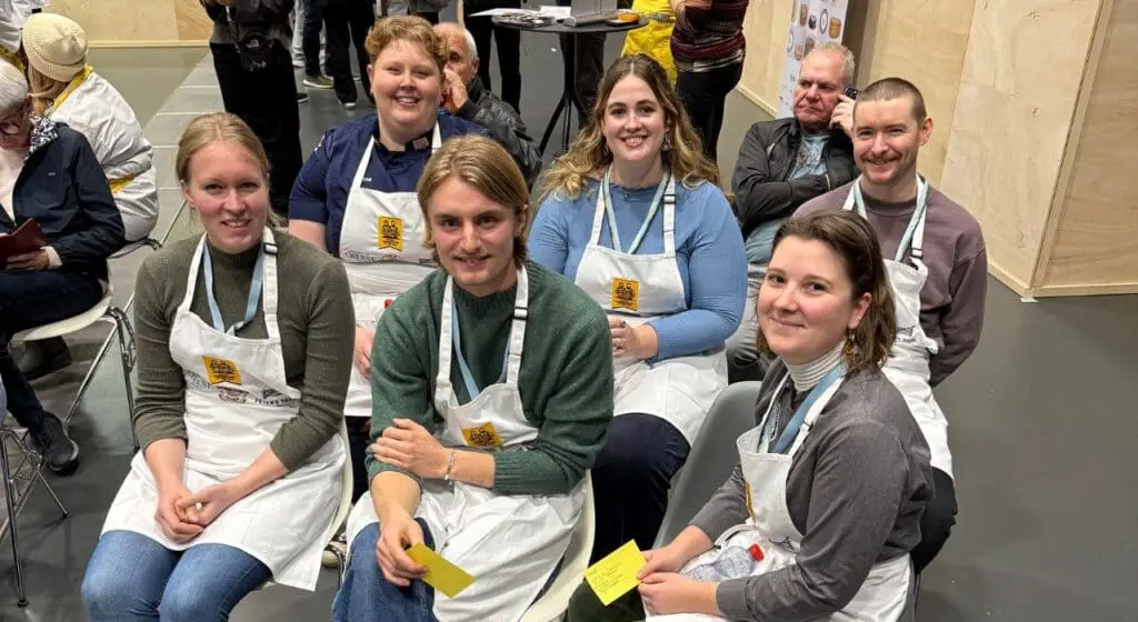 A group of six people sitting together smiling.