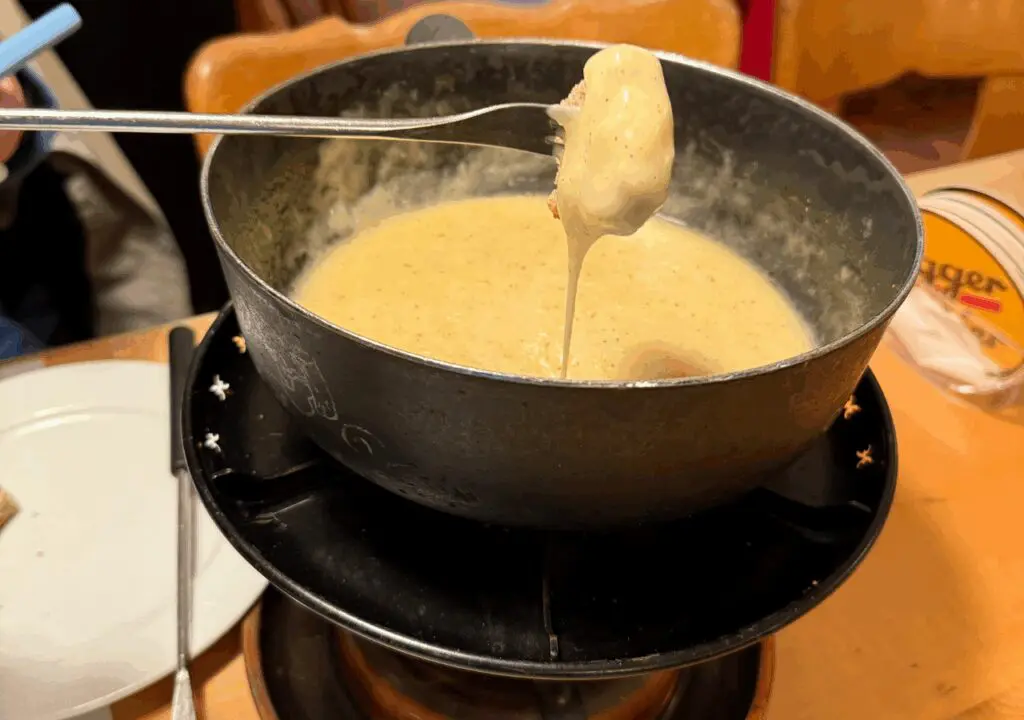 Cheese Fondue with a piece of bread being dipped