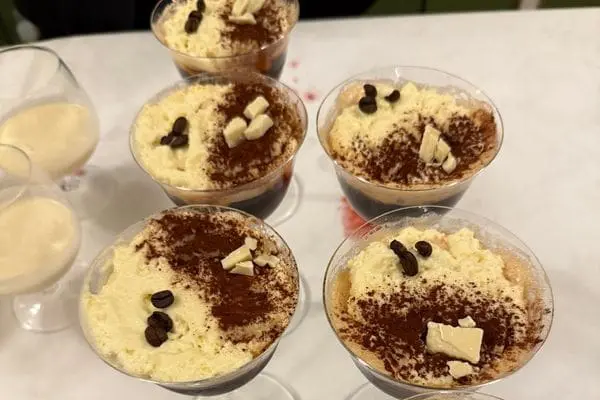 Five espresso-martini-styled cockails with a stilton foam, white chocolate and coffee beans on the top.