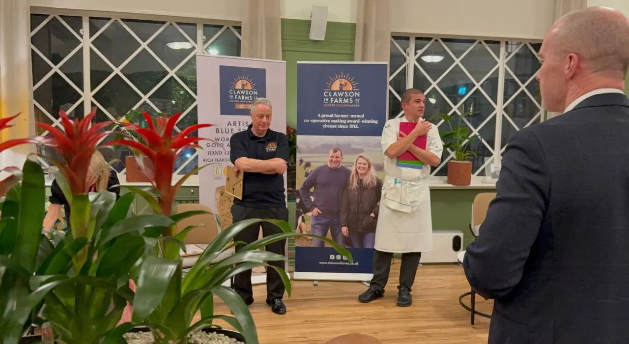Two men standing in front of Clawson Farms' Pop up banner
