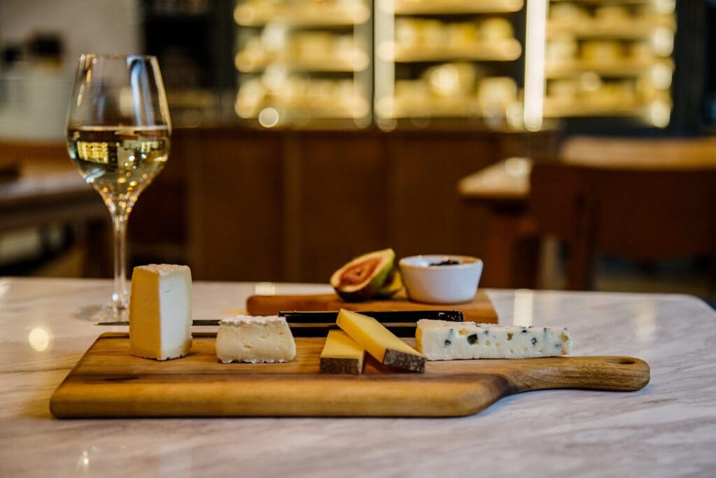 Selection of cheeses with a glass of white wine and a fig