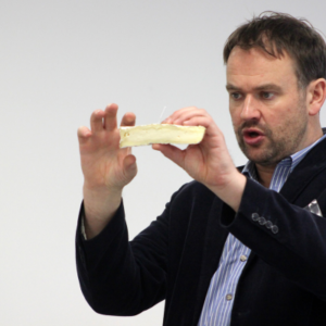 Charlie Turnbull holding a piece of Brie de Meaux